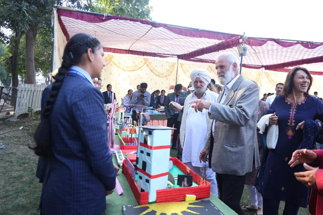A student presenting exhibition models to visitors